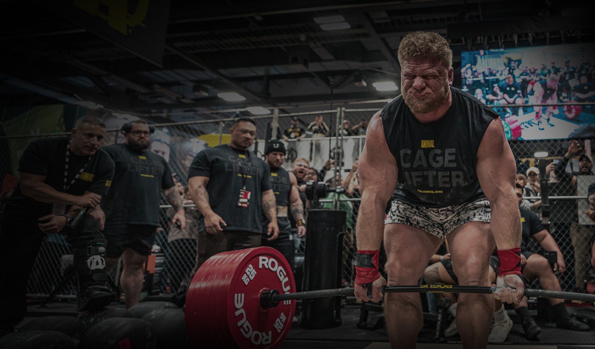 Athlete lifting weights at a powerlifting competition with spectators in the background.